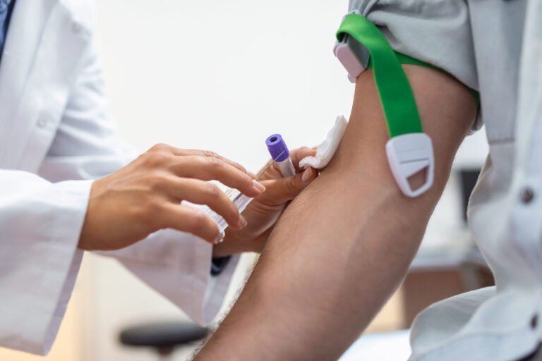 Nurse collecting a blood sample from a patient