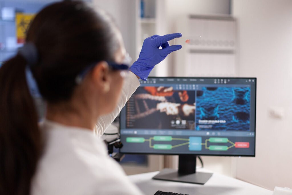 Scientist holding a blood smear slide in a hematology lab