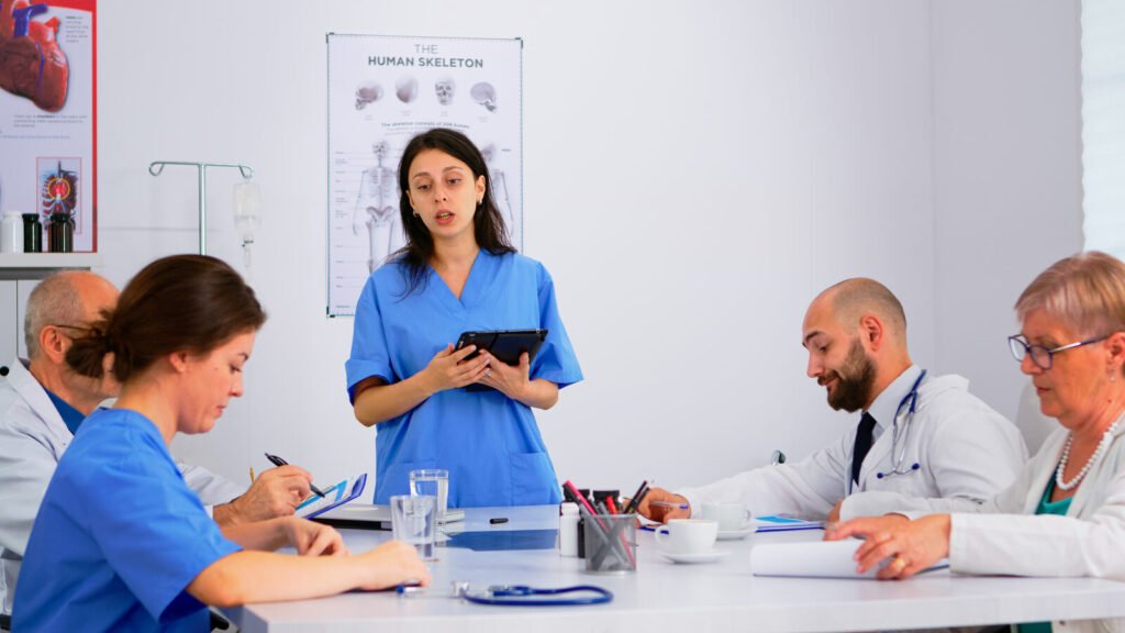 Hospital team discussing options around a table with a tablet