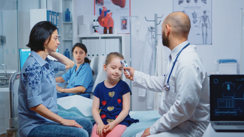 Doctor checking the temperature of a young child