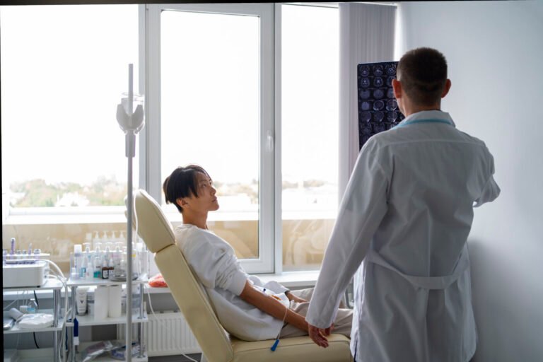 Doctor talking with a patient seated in a treatment chair