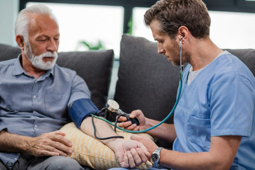 Healthcare worker checking blood pressure during a home visit