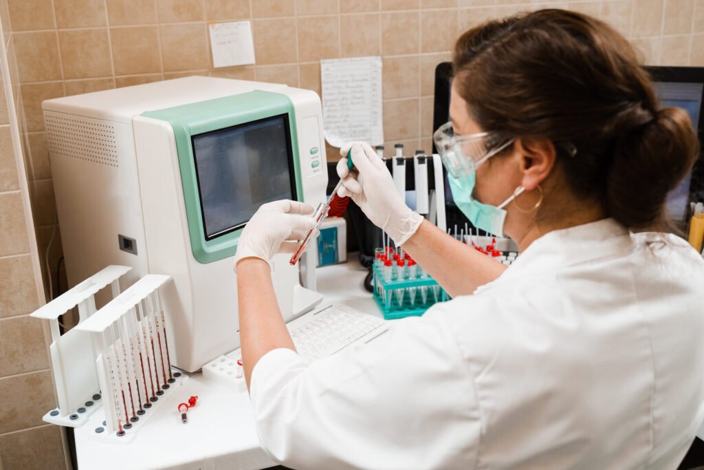 Laboratory assistant operating an automated blood analyser