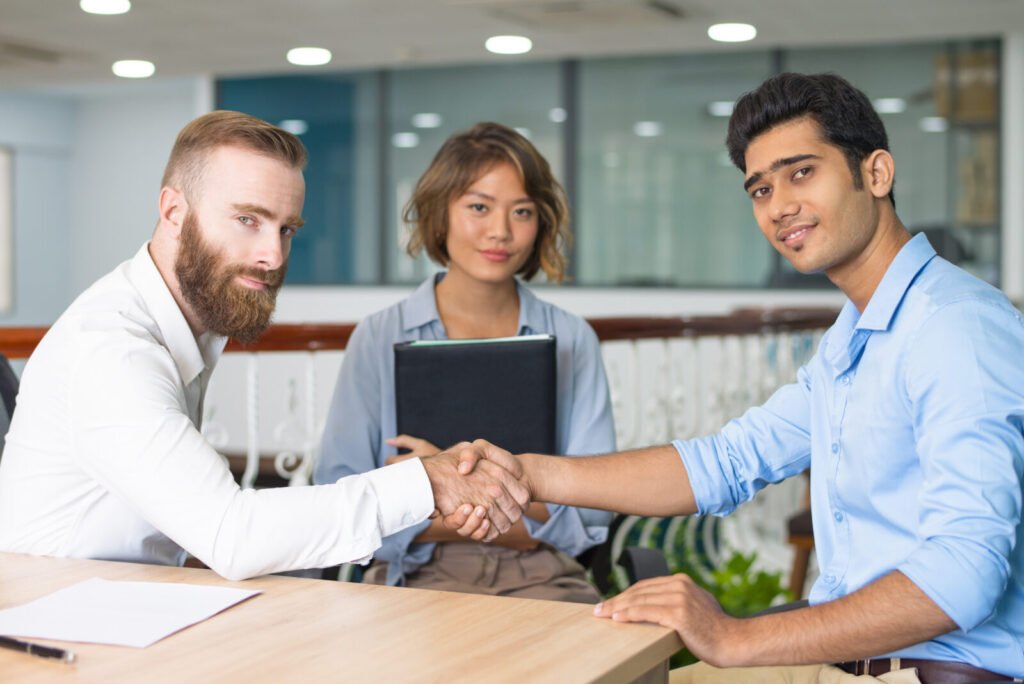 Hiring manager shaking hands with a new candidate in an office