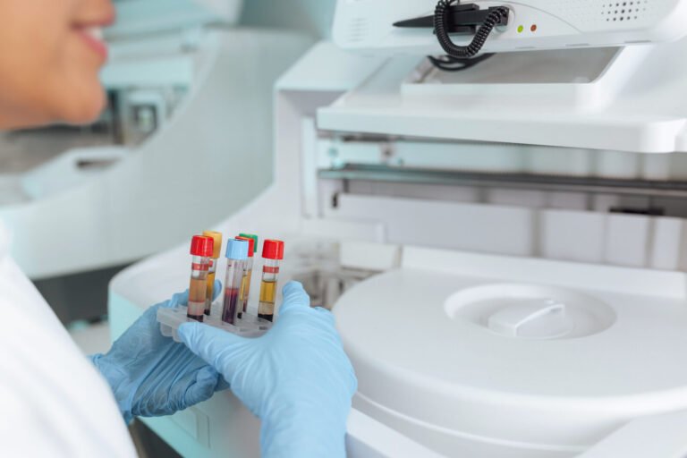 Laboratory scientist running blood samples on a haematology analyser