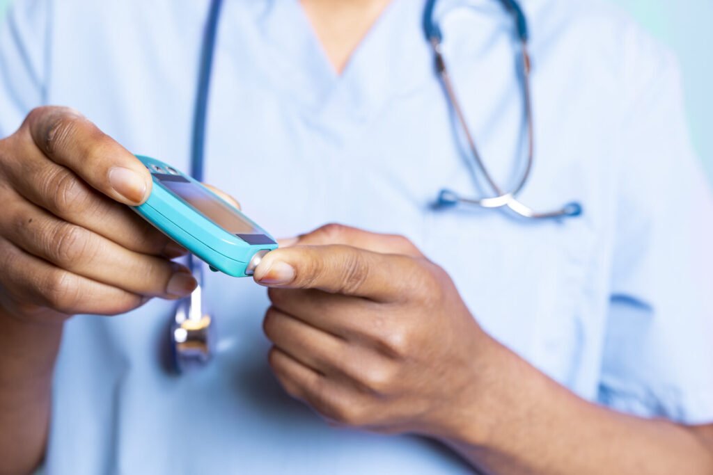 Clinician running a finger-prick blood test on a handheld meter