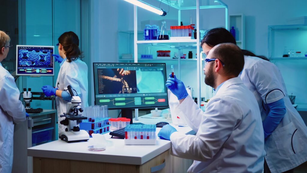 Technician taking a sample tube from a rack beside laboratory analyzers
