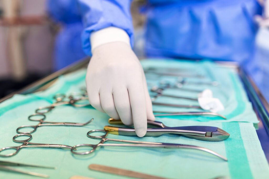 Surgeon picking up a surgical instrument from the tray